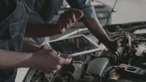 Diverse Mechanics Testing Car Engine with Tablet and Voltmeter Video stock 280321524