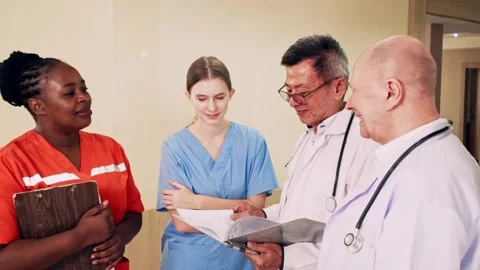 Diverse medical team of doctors and nurses discuss patient records in hospital. Stock Footage 312821663
