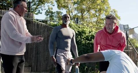 Diverse men clapping after workout, Senior African American man handing water Stock Footage 342085243