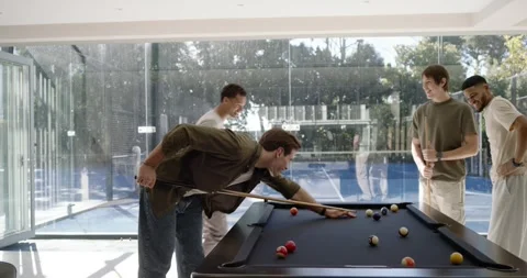 Diverse men discussing ball layout urging green-shirt man lining shot in game Stock Footage 339959750