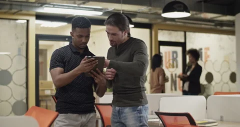 Diverse men discussing data on tablet Stock Footage 195218103