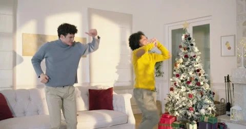 Diverse men laughing after man showing phone, then dancing in living room by Stock Footage 344461209