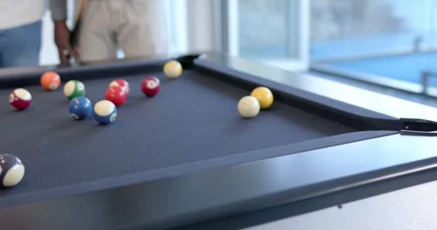 Diverse men playing on pool table, cue hitting ball, jacketed man celebrating Stock-Footage 342068603