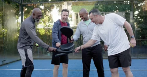 Diverse men shifting, stacking paddles, swirling yellow ball, raising paddles on Stock Footage 342033385
