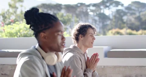 Diverse men sitting on balcony, clapping, starting meditation, pressing hands in Stock Footage 346179999
