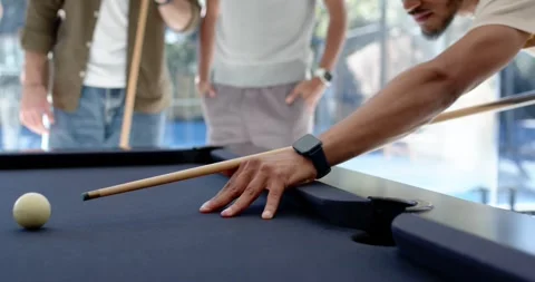 Diverse men watching shooter lining cue on pool table, striking cue ball to sink Stock-Footage 342032561