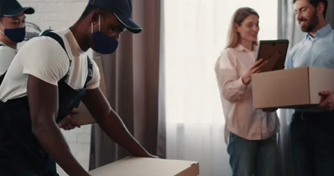 Diverse Men Workers of Relocation Service Delivering Boxes for Married Couple Stock Footage 172080535