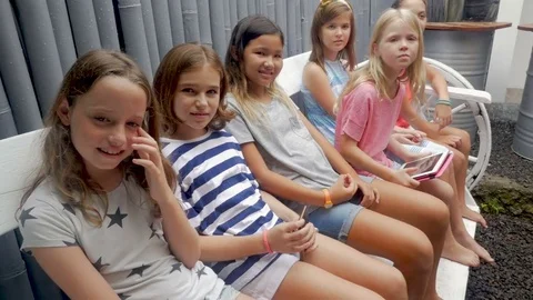 Diverse multi ethnic group of young girls sitting on a bench Stock Footage 85379200