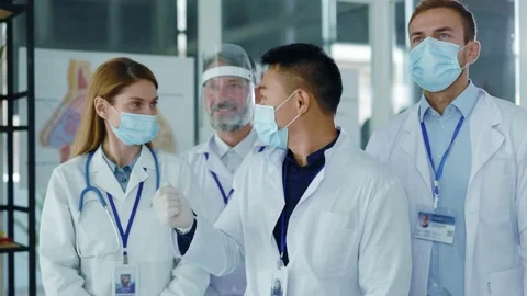 Diverse multi-ethnic team of young doctors talking to asian boss collaborating Stock Footage 142846123