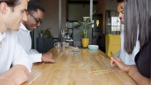 Diverse office team enjoys a fun Mikado game during a work break fostering unity Vidéo 335747772