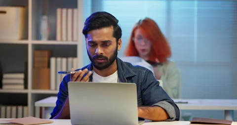 Diverse office workers using AI voice assistants on smartphones in modern worksp Stock Footage 335851801