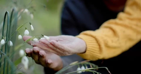 Diverse pair with man steadying white bells, senior Asian woman in yellow Vídeo Stock 345509754