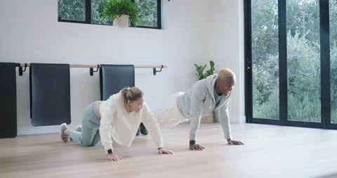 Diverse partners starting, doing push-ups by barre while man adding knee drives Stock Footage 344678296