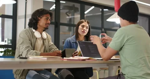Diverse peers collaborating as right speaker gesturing, explaining laptop code Stock Footage 344645015