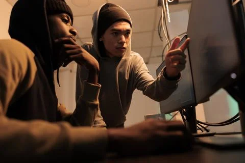 Diverse people doing teamwork to break into computer system Stock Photos