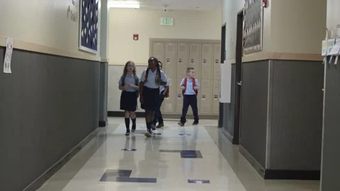 Diverse Primary and Elementary school children walk school hall in uniforms. Video stock 139655736