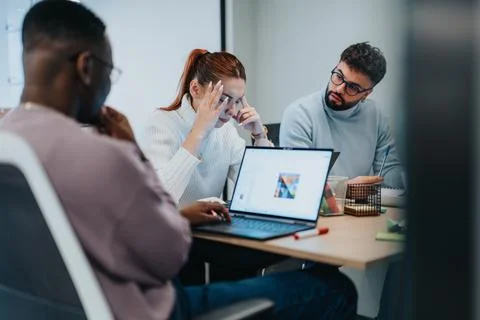 Diverse professionals collaborating on a project in a modern office, focusing on Stock Photos