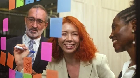 Diverse professionals smiling and collaborating during a brainstorming session Stock Footage 322217843