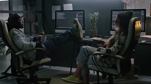 Diverse Programmers Chilling Out and Chatting at Desks at Night Stock Footage 273833486