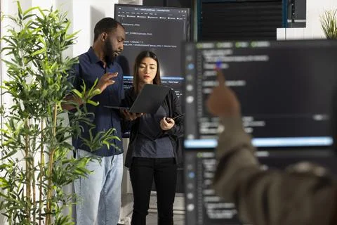 Diverse programmers comparing code to improve company website 写真素材