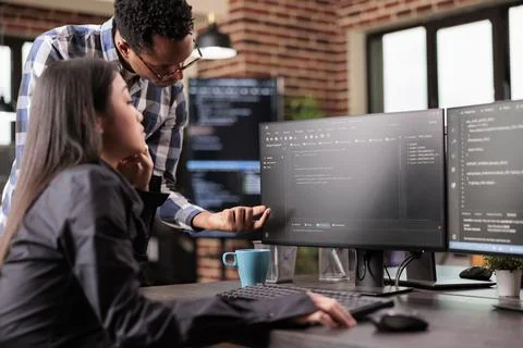 Diverse programmers discussing about html code Stock Photos