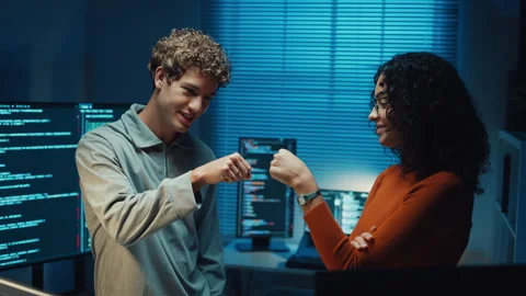 Diverse programmers give fist bump to celebrate success in dark office at night. 스톡 동영상 347148607