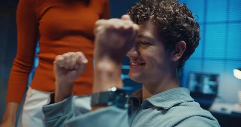 Diverse programmers give fist bump to celebrate success in dark office at night. Stock-Footage 347148657