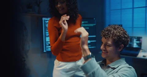 Diverse programmers give fist bump to celebrate success in dark office at night. Vídeos de archivo 347148758