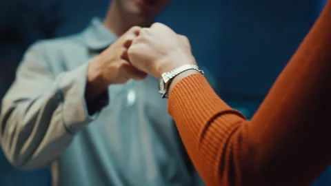 Diverse programmers give fist bump to celebrate success in dark office at night. Vídeo Stock 347148765