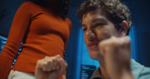 Diverse programmers give fist bump to celebrate success in dark office at night. Stock-Footage 347148819