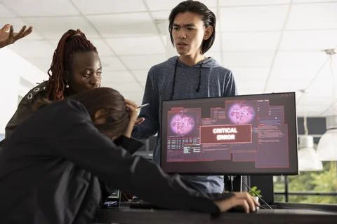 Diverse programmers reacting to sudden system error alert on computer Stock Photos