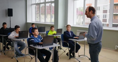 Diverse School Children In Classroom, Boy Asking Teacher, Students Sitting At Stock Footage 280181092