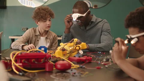 Diverse Schoolboys Constructing Robots in Class with Teacher Video stock 204896794