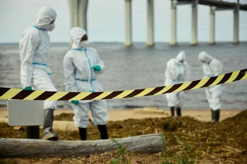 Diverse Scientists in Hazmat Suits Inspecting Water Pollution Stock Photos