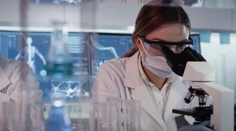 Diverse scientists studying brainwave scanning and human skeleton Stock Photos