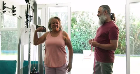 Diverse senior client and trainer entering gym with tape measuring client arms Stock Footage 341735938