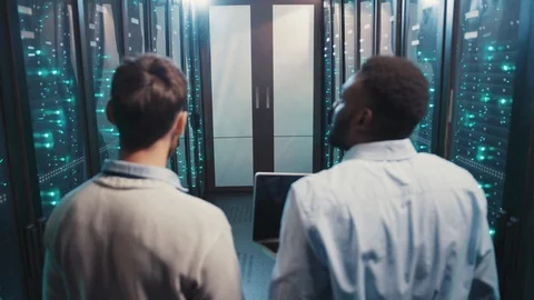 Diverse server engineers inspecting server computers in rack cabinets Video stock 119232650