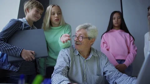Diverse smart pupils discussing solution of study task on laptop with teacher Stock Footage 142502558