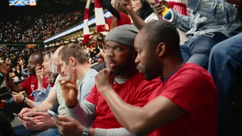 Diverse soccer fans using mobile sportsbook app during live football match Stock Footage 335675744
