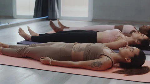 Diverse Sportswomen Practicing Corpse Pose on Floor Stock Footage 258578211