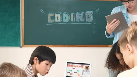 Diverse student working while teacher hold tablet and check work. Pedagogy. Stock Footage 279894645