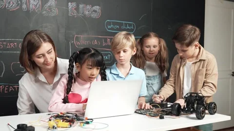 Diverse student writing engineering code while boy fixing board. Erudition. Stock Footage 263073327