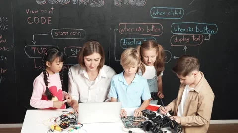Diverse student writing engineering code while boy fixing board. Erudition. Stock Footage 271169589