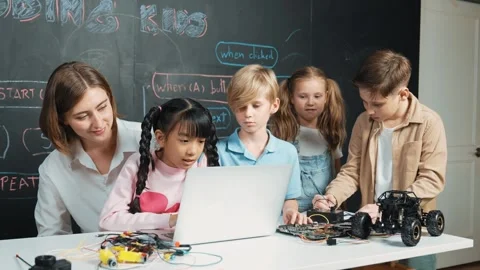 Diverse student writing engineering code while boy fixing board. Erudition. Stock Footage 281369242