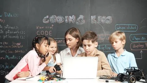 Diverse student writing engineering code while boy fixing board. Erudition. Foto stock