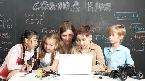 Diverse student writing engineering code while boy fixing board. Erudition. Foto stock