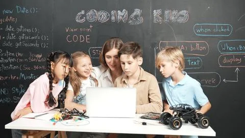 Diverse student writing engineering code while boy fixing board. Erudition. Foto stock