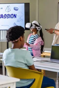 Diverse students and instructor exploring virtual reality headset in classroom 스톡 사진