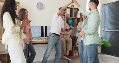 Diverse students celebrating teamwork success in group project meeting classroom Stock Footage 340405265