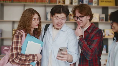 Diverse students in classroom using smartphone for learning and socializing Stock Footage 341337409